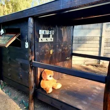 Raised bed and café corner details of a timber K9 cabin at golden hour